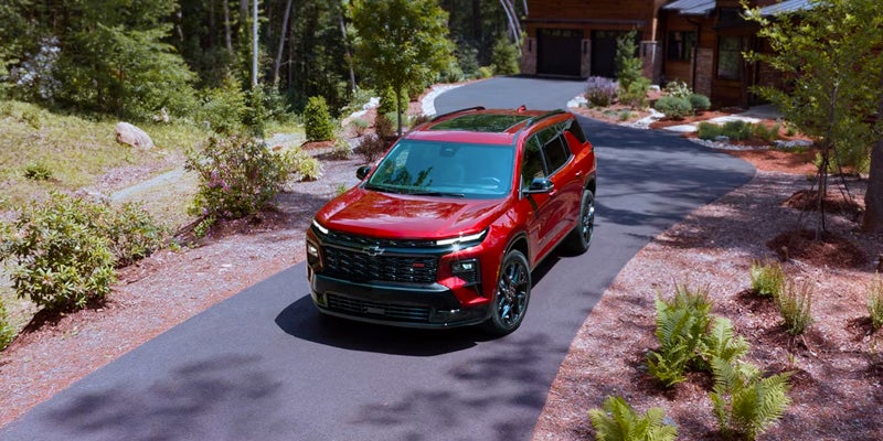 A red 2024 Chevrolet Traverse parked in a driveway