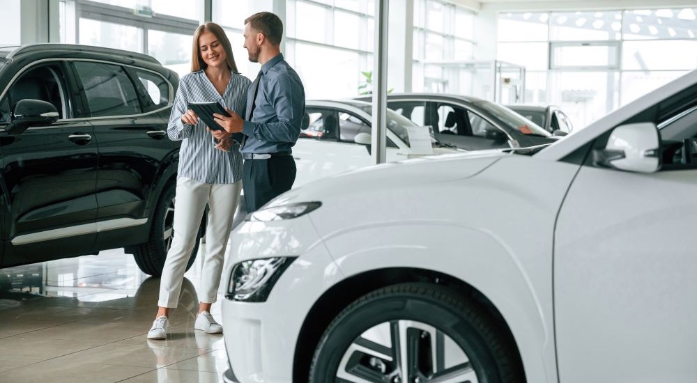 People looking at a tablet in a car dealership