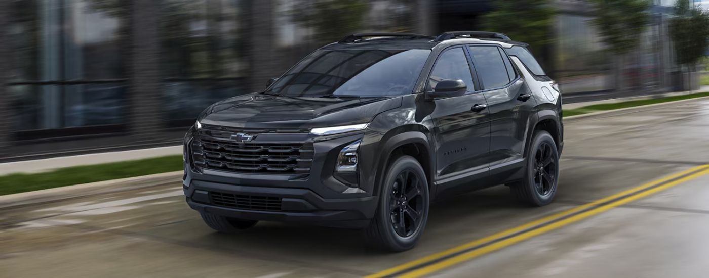 Black 2026 Chevy Equinox driving on a city road.