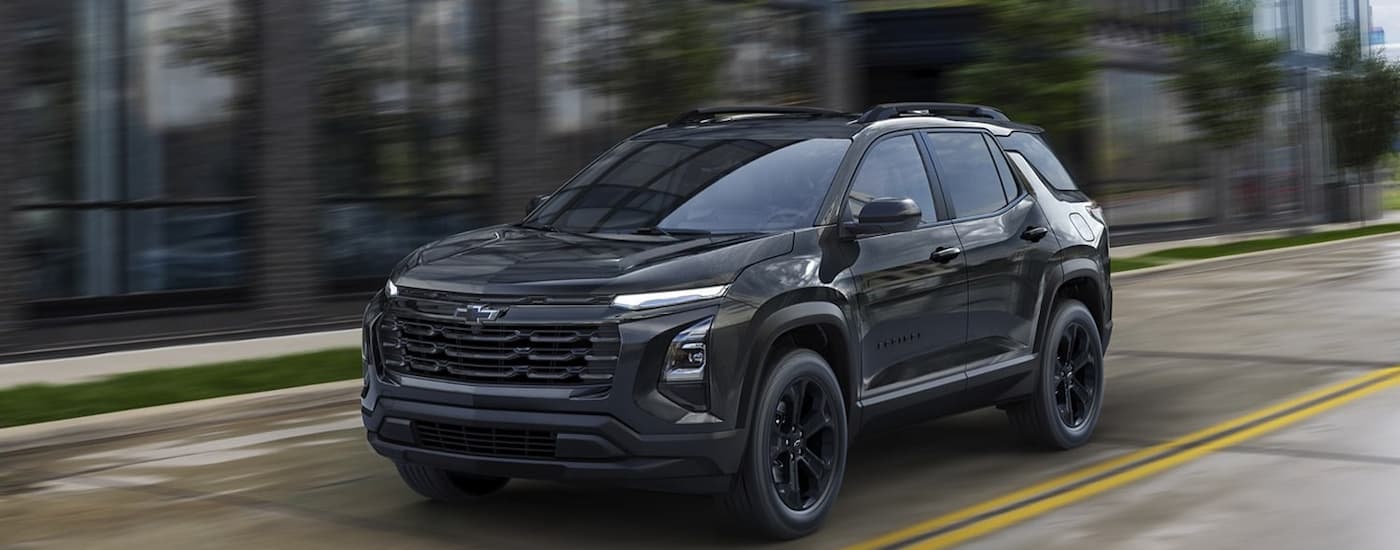 Black 2026 Chevy Equinox driving down an open road.