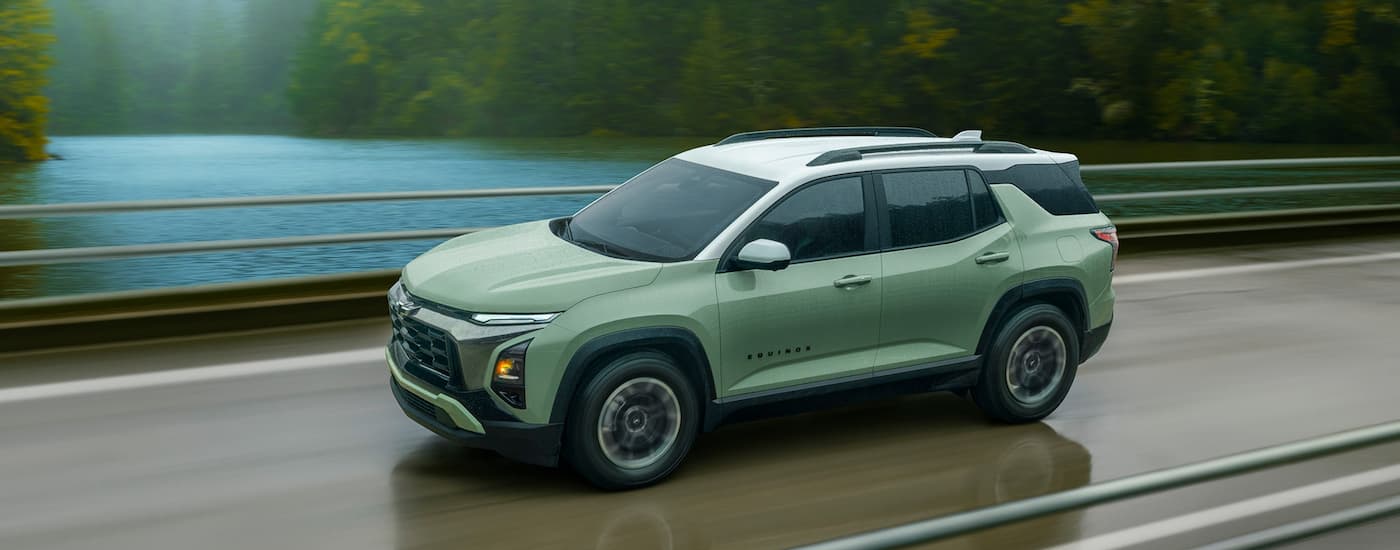 Green 2026 Chevy Equinox driving down a bridge.