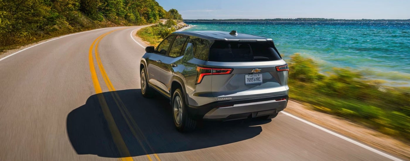 Grey 2026 Chevy Equinox LT driving past a lake