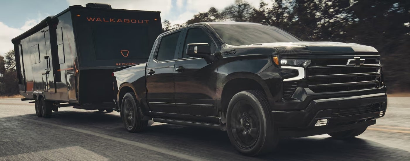 Black 2026 Chevy Silverado 1500 High Country towing a trailer