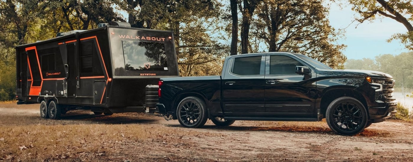 Black 2026 Chevy Silverado 1500 High Country towing a trailer