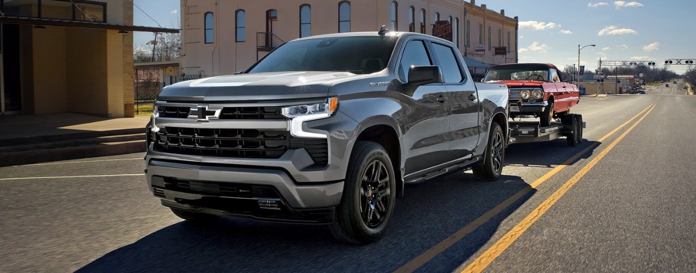 Silver 2026 Chevy Silverado 1500 RST towing a car