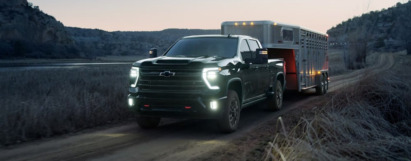 Black 2026 Chevy Silverado 2500 HD LTZ Trail Boss towing a trailer