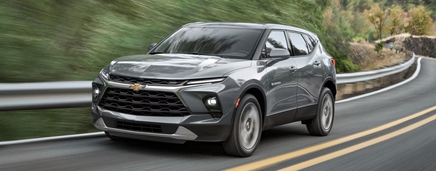 Grey 2026 Chevy Blazer driving on a paved road.