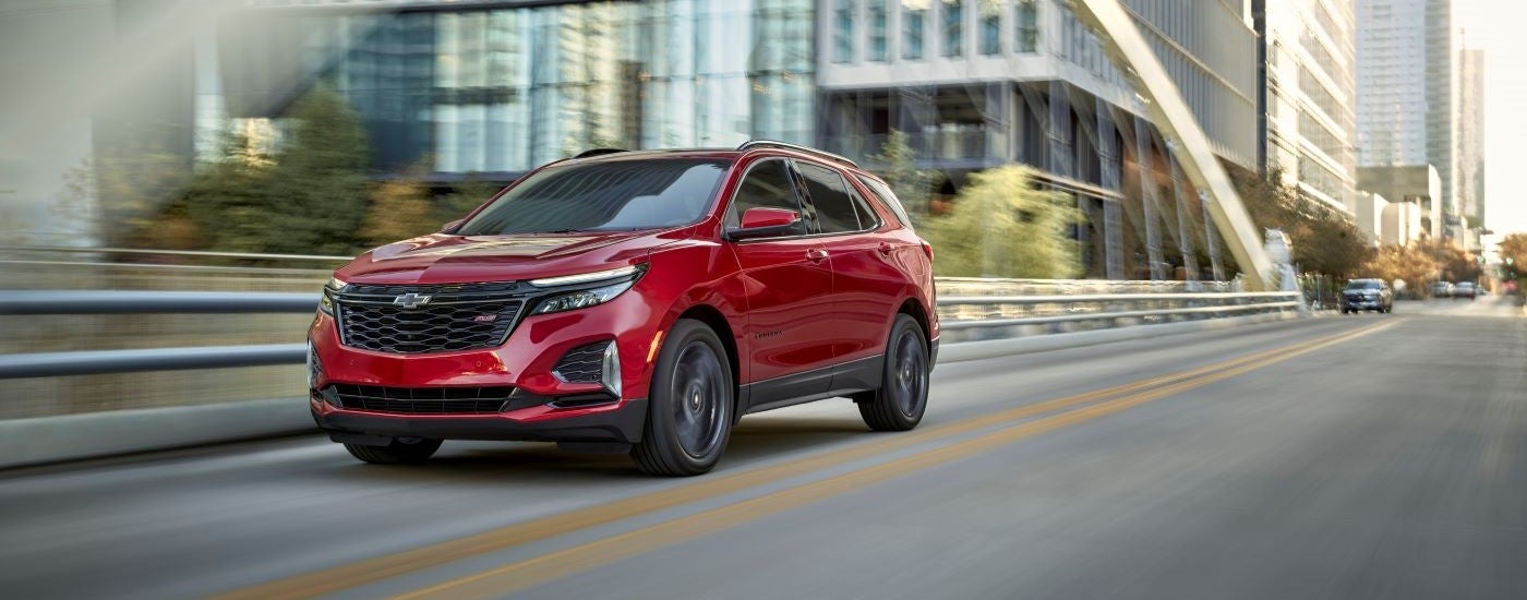 A red 2024 Chevy Equinox RS crossing a bridge.
