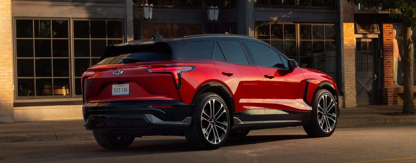 A red 2026 Chevy Blazer EV parked by a building.
